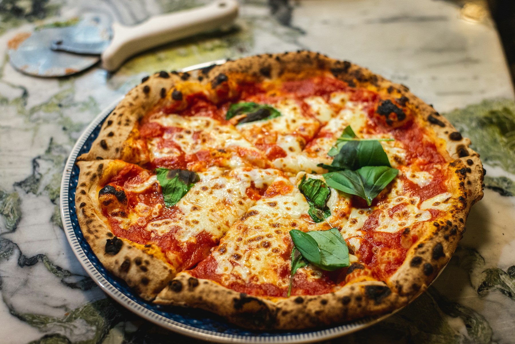 Fresh pizza with charred crust and basil